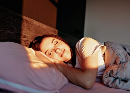 lovely appealing girl with happy smile is sleeping on bed